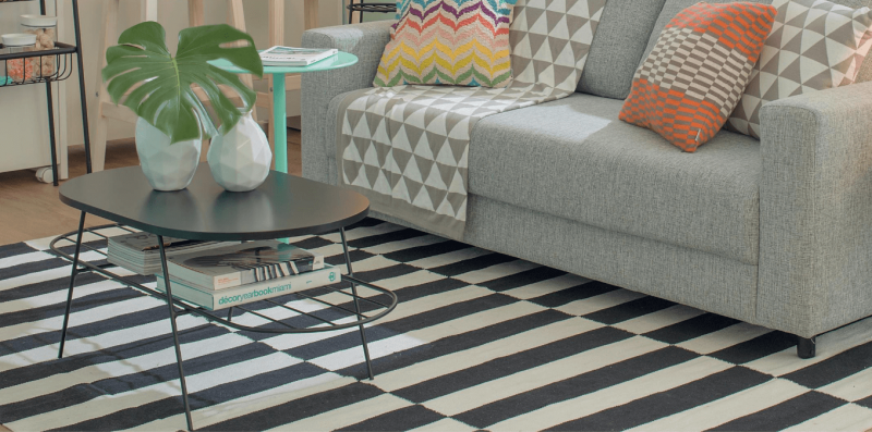 Tapetes estampados e listrados brincam com as formas do ambiente