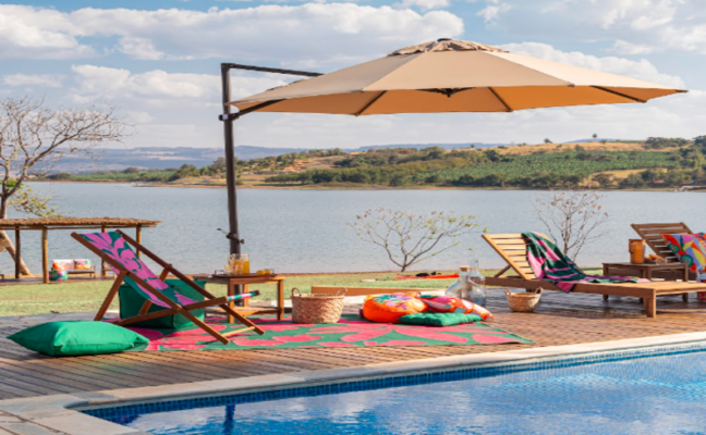 ombrelone área externa com piscina, espreguiçadeira, almofada, chaises e outros itens decorativos