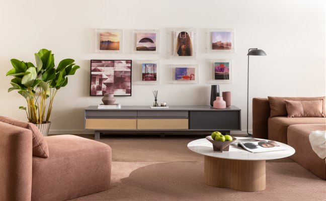 sala de estar com quadros decorativos, poltrona, sofá, mesa de centro, rack luminária de chão e diversos itens decorativos.