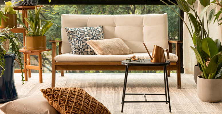 tipos de varandas com sofá, mesa de centro e diversos vasos decorativos