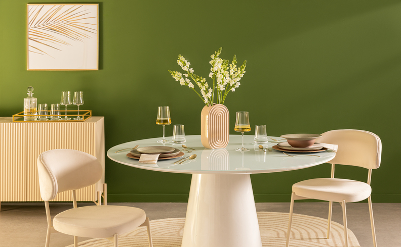 mesa de jantar black friday no modelo redondo com base de madeira, além de duas cadeiras, buffet, vaso com flor e mesa posta.