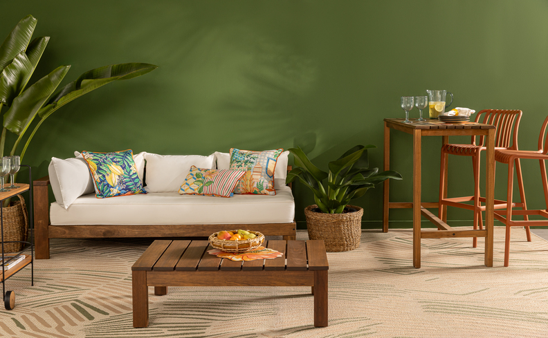 sofá black friday em madeira com estofado branco para a área da varanda, além de mesa de centro, mesa redonda pequena, banquetas e almofadas.