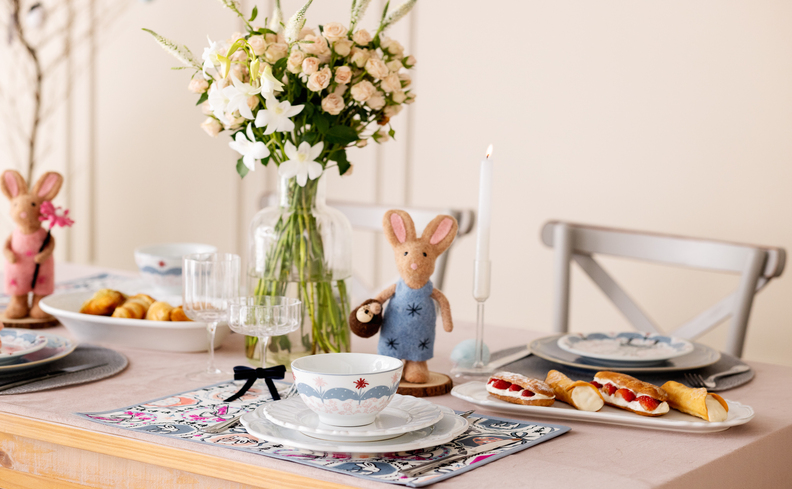 decoração de páscoa para mesa posta com diversos coelhos de pelúcia, além de opções de decoração nas louças, jogo americano e muito mais