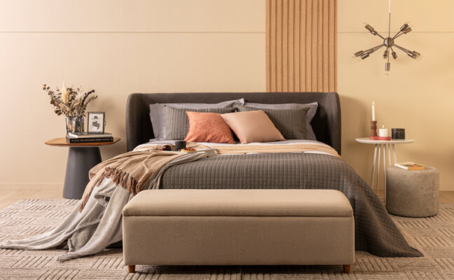 itens para primeiro apartamento, quarto com cama posta com edredom, travesseiros, almofadas, mesa de cabeceira e outros itens