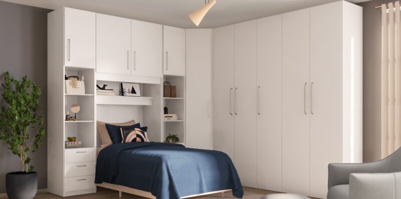 Guarda-roupas grande em L com as portas fechadas e espaço para cama de casal.