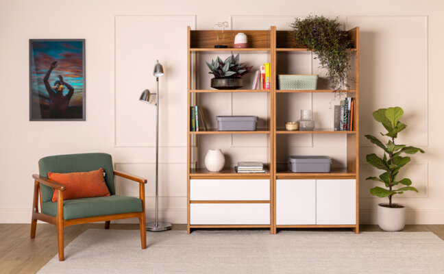 casa organizada em um ambiente de sala de estar com poltrona, estante com diversos objetos decorativos e organizadores