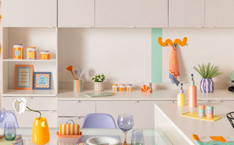 como organizar cozinha pequena com armários brancos, itens decorativos coloridos como vasos, utensílios de preparo de silicone, ganchos, porta temperos e muito mais que auxiliam na organização.