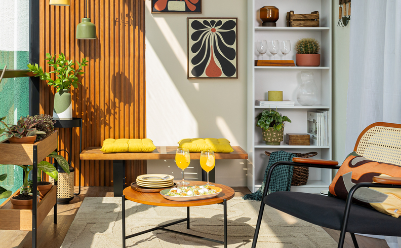 varanda de apartamento pequeno com estante vertical, mesa, bancos e cadeiras para aproveitar todo o espaço disponível.
