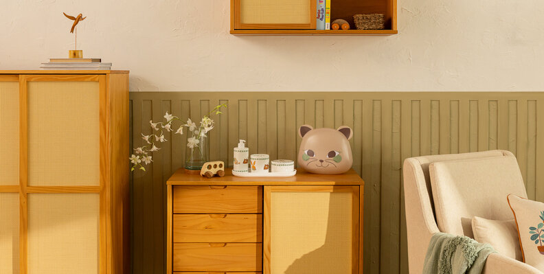 dicas de organização de quarto infantil com prateleira para quarto infantil, cômoda, guarda-roupa e poltrona, além de adornos decorativos, manta e vaso com flores.