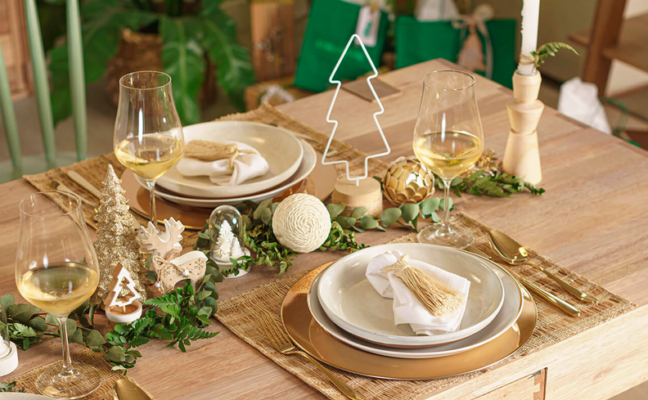 mesa posta de natal com pratos, enfeites natalinos, talheres e outros itens