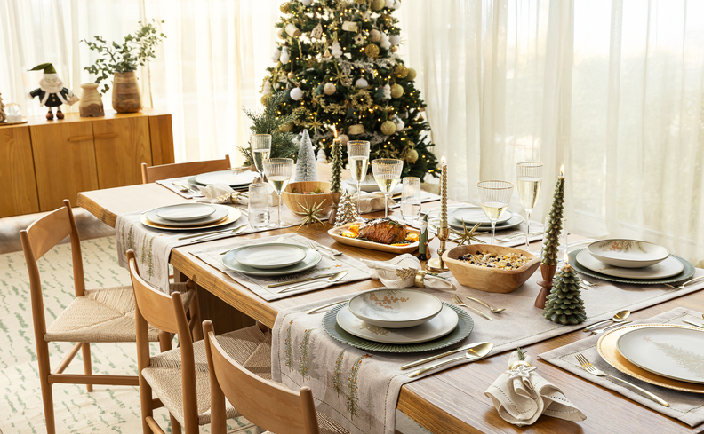 o que dar de presentes de natal para a família, sala de jantar com mesa posta para a ceia de natal, árvore de natal e diversos presentes na árvore.
