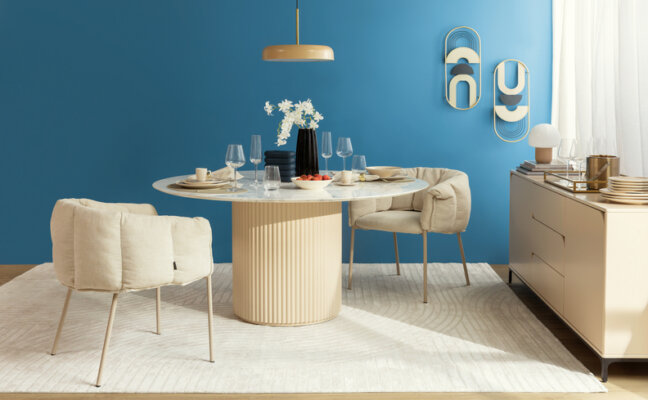 opções de modelos de mesa de jantar com uma mesa redonda, duas cadeiras brancas com braços, tapete branco, lustre pendente, buffet ao lado para complementar a decoração e deixar o ambiente organizado e funcional.