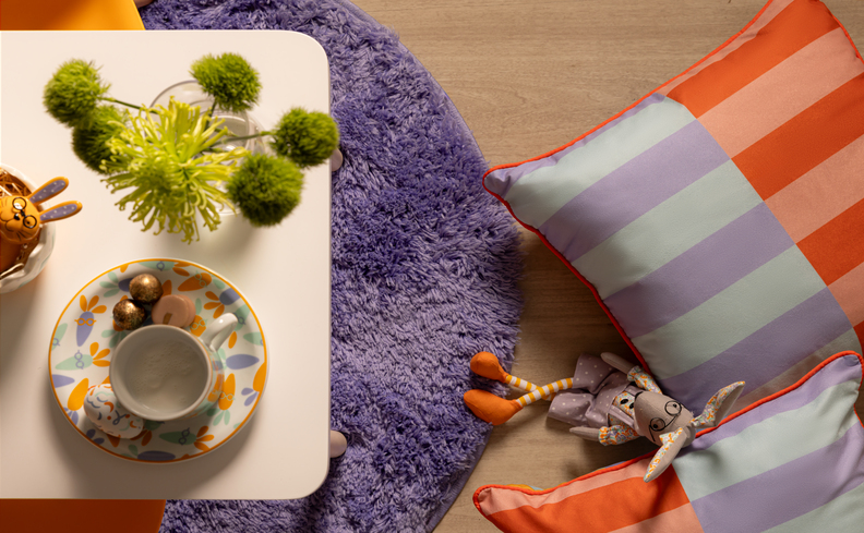 almoço de páscoa com mesa posta com prato, tigela, vaso com planta, coelhos de pelúcia e muito mais