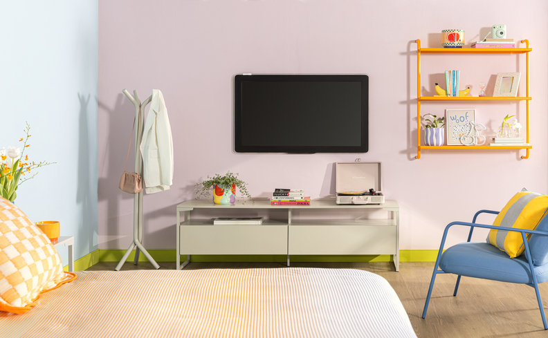 pequenos espaços na casa em um quarto de casal com cama, rack, televisão, prateleira amarela, poltrona azul, almofada e cabideiro de chão.