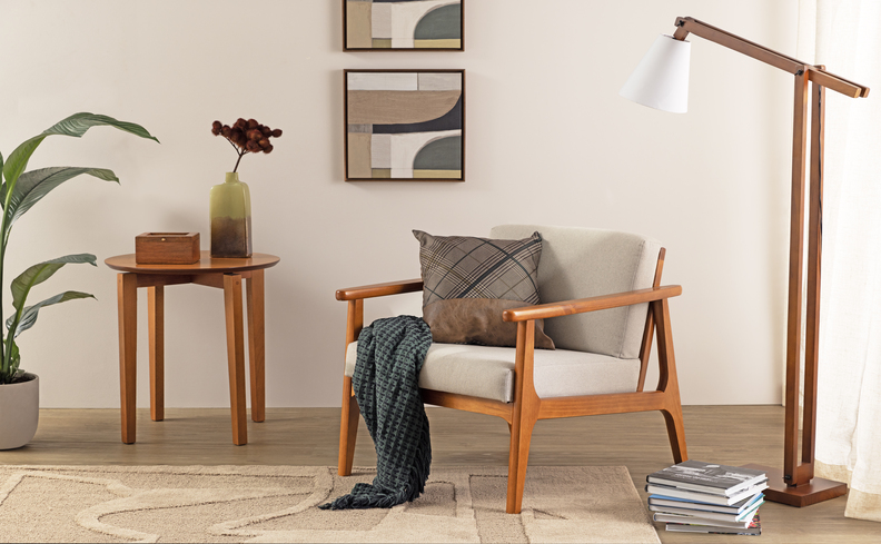 cantinho da leitura em casa com poltrona, almofada, manta, mesa de apoio, luminária de chão, tapete e diversos itens decorativos