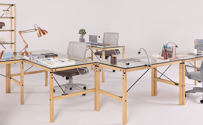 mesas de escritório com computadores e luminárias de mesa em cima