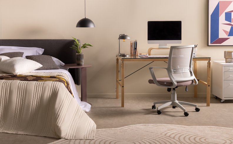 quarto com cama, pendente, cadeira de escritório e escrivaninha com computador e luminária de mesa
