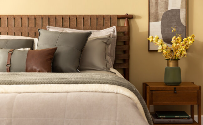 cama decorada com porta-travesseiros, almofadas e edredom