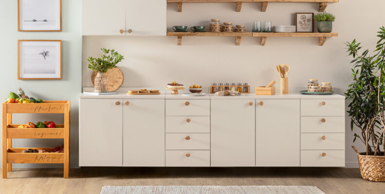 cozinha decorada com paleta de tons neutros com armário branco, estantes e fruteiras e prateleiras.