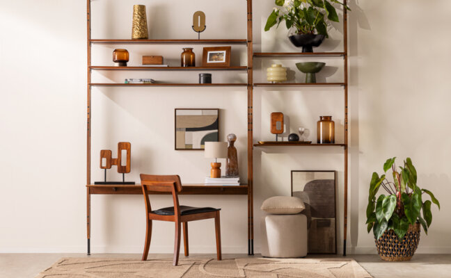 Entre os modelos de estante, uma opção para a sala de estar, com escrivaninha e cadeira, além de diversos itens decorativos