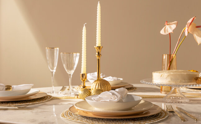 mesa de ano novo completa com pratos, velas, taças e outros itens de mesa posta