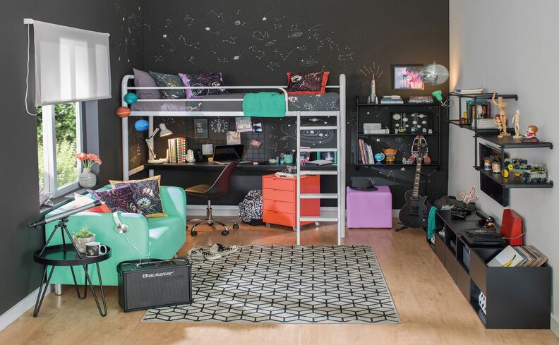 escrivaninha em quarto de adolescente com cama, cômoda, tapete e outros itens