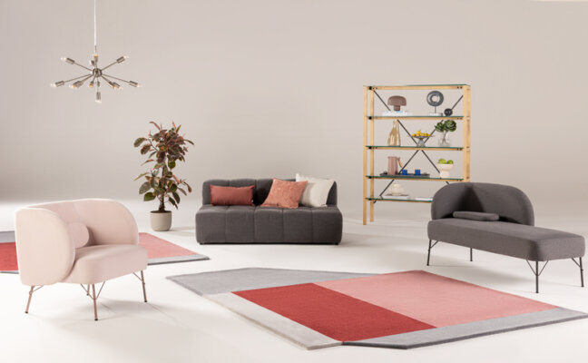 decoração de recepção com sofás, poltrona, tapete, estante e outros itens decorativos