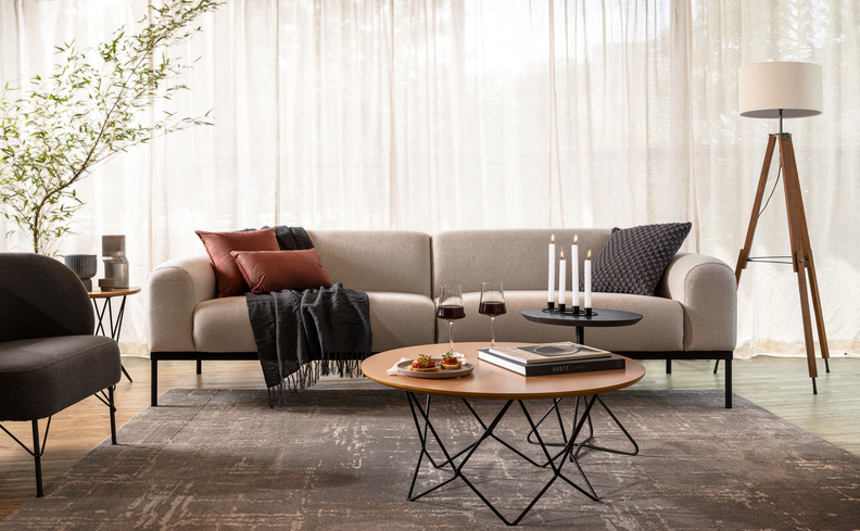 sala de estar com estilo contemporâneo decoração com sofá, almofadas, tapete, poltrona, luminária de chão, mesa de centro e outros itens decorativos