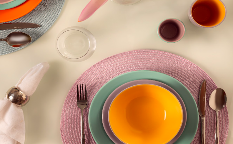 mesa posta para café da tarde com jogo americano, pratos rasos e fundos, talheres, copos, xícaras e guardanapo de tecido para aproveitar o dia do café