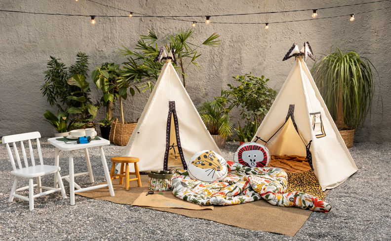 iluminação para jardim externo com cabanas para crianças, cordão com luzes e cadeira e mesa infantil