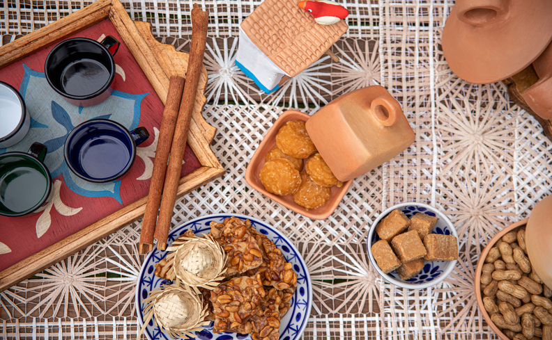 comidas para servir na festa junina em casa com paçoca, bolo, arroz doce e muito mais em uma mesa posta com a decoração da época