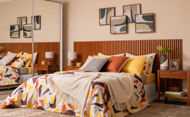 como escolher roupa de cama confortável, quarto com roupa de cama colorida, mesa de cabeceira e quadros decorativos