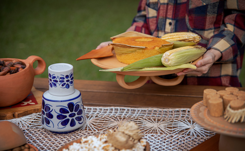 decoração para festa junina em casa com mesa posta com comidas típicas como milho, pipoca e muito mais