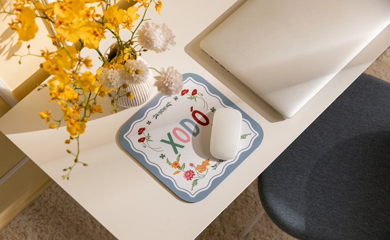 tons de azul pastel na decoração estilo romântico com mouse pad, vaso com flores amarelas em uma escrivaninha