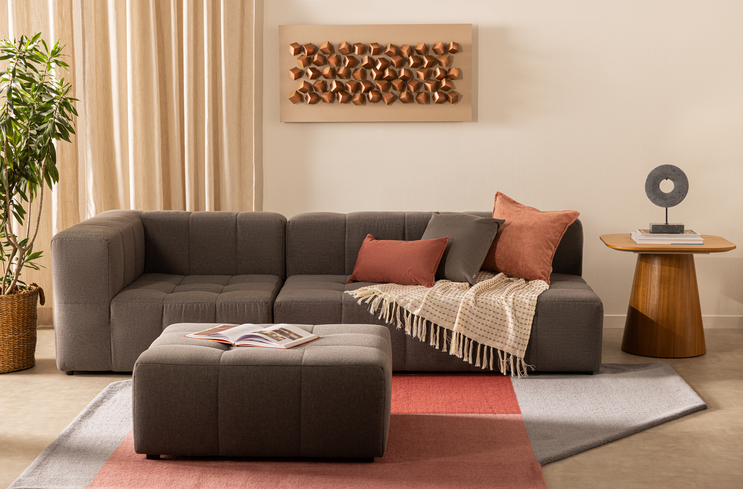 como decorar sofá com manta e almofadas em uma sala de estar para ter uma decoração de inverno com tapete, sofá cinza e itens decorativos.