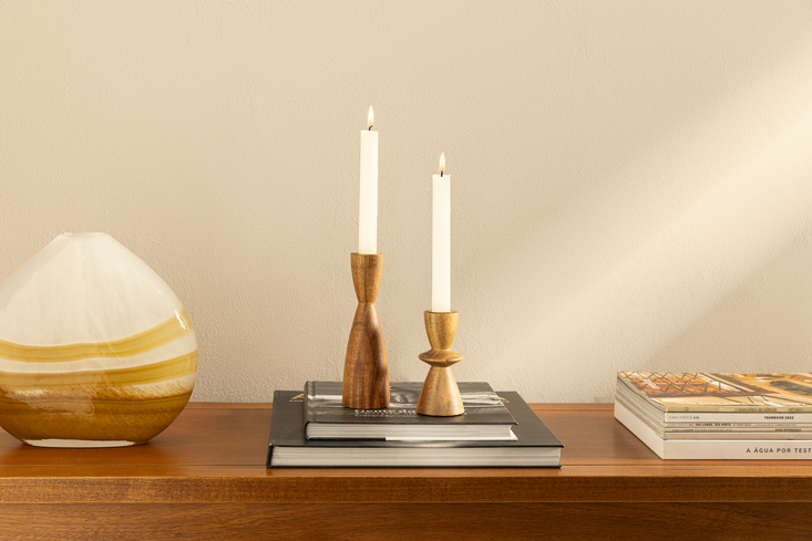 decoração de inverno com velas em castiçais, vaso e livros decorativos em um aparador