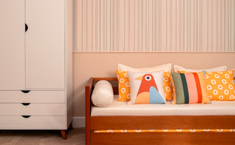 quarto com um guarda-roupa de solteiro, bicama, almofadas e travesseiros.
