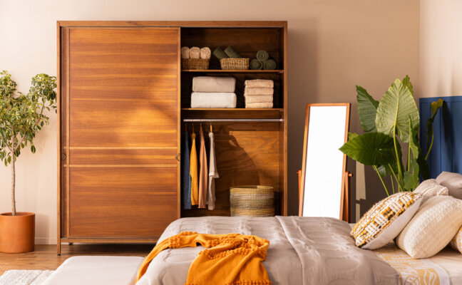 tamanho de guarda-roupa de madeira 2 portas em um quarto de casal, além de conter cama, almofadas e edredom