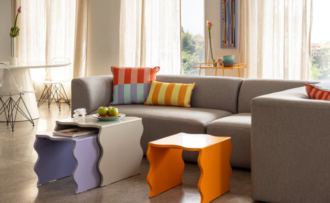 sala de estar com sofá, almofadas coloridas, mesas de centro e de apoio para decorar e deixar o ambiente prático.