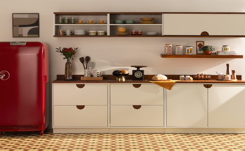 bancada de cozinha organizada com utensílios mais usados na rotina, potes organizadores, balança, pratos e bowls nos armários e um vaso com planta para decorar.