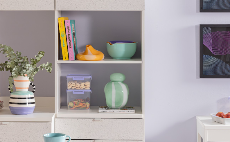 cozinha de apartamento pequeno com armário com prateleiras e potes organizadores, além de diversos itens de decoração.