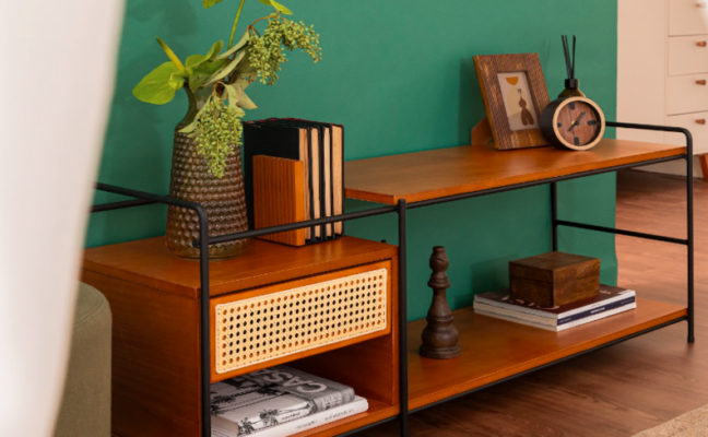 como decorar um rack de sala com gavetas e nichos vazados, com itens como livros, vasos com plantas e porta-retratos.