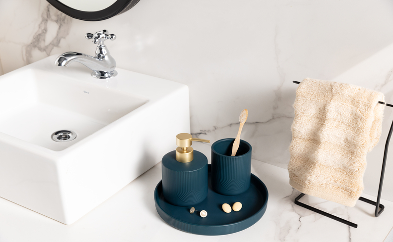 kit presente de casa nova com itens para o banheiro como porta sabonete líquido, porta escova de dente e toalhas de rosto.