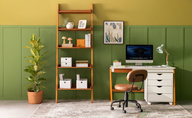 o que dar de presente de casa nova para organizar um escritório com escrivaninha, cadeira, vaso com planta e uma estante com diversos itens decorativos.