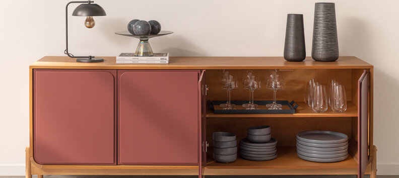 presentes de casa nova com diversas taças, pratos e copos em um buffet na sala de jantar.