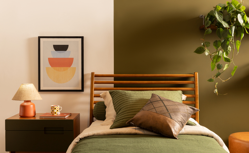 quarto de adolescente decoração em tons de verde com roupa de cama verde, almofadas e travesseiros, além de mesa de cabeceira com luminária de mesa e quadro decorativo na parede.