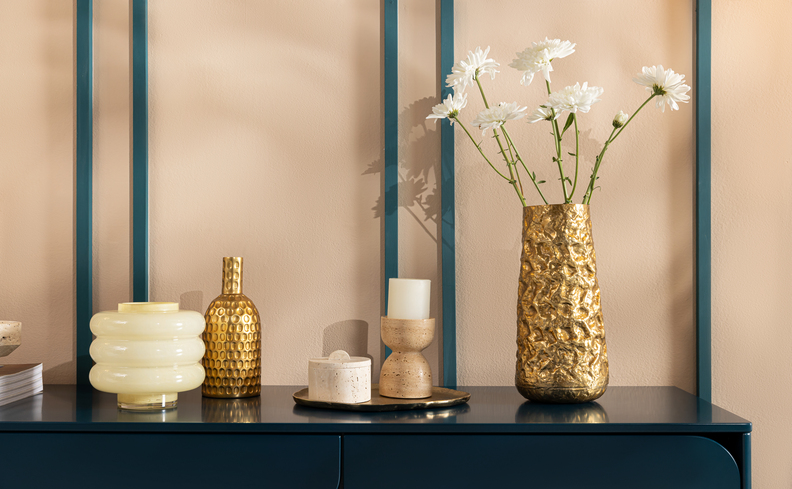 rack de sala pequeno com vaso com plantas, velas, difusor, bandeja, vela, vasos, entre outros itens.