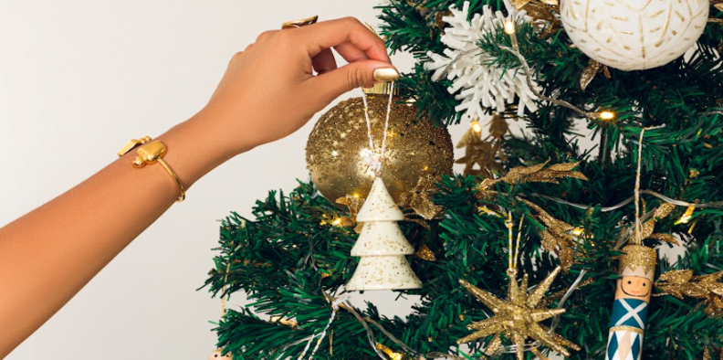 decoração de natal para casa pequenas com enfeite de porta para natal de mini árvore branca em uma árvore com enfeites dourados e brancos.