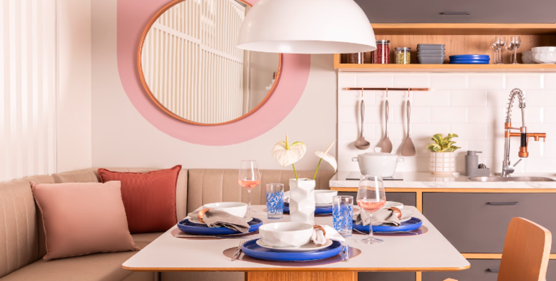 decoração para sala de jantar com espelho redondo em um canto alemão com duas cadeiras e integrado com a cozinha.