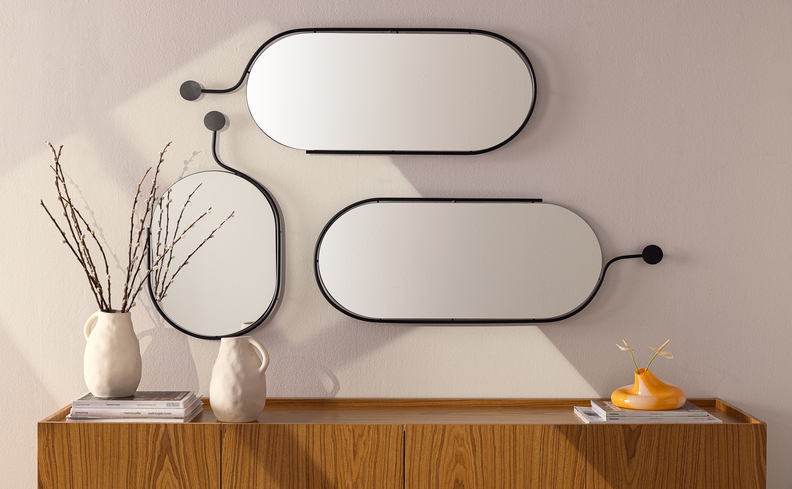 espelho decorativo para sala de jantar em diversos tamanhos  em cima de um buffet com vasos e flores para complementar a decoração.